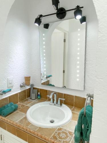 a bathroom with a sink and a large mirror at Brisas Shores 07 Beachfront Condo, Pool and garden area, Zona Hotelera Cancun in Cancún
