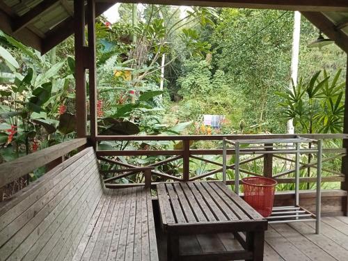 - une terrasse couverte en bois avec un banc dans l'établissement Thousand hills ketambe, à Lhokuenam