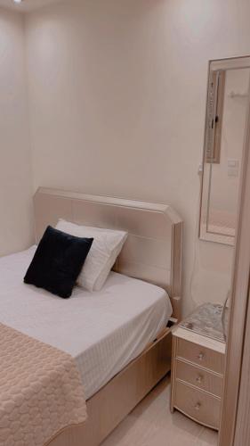 a bedroom with a bed with a black pillow on it at El mansour hotel apartmen 84 in Mansoura