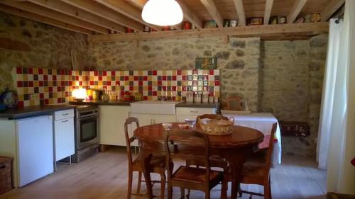 une cuisine avec une table et des chaises dans une cuisine dans l'établissement Maison traditionnelle catalane avec jardin, à Thuès-entre-Valls