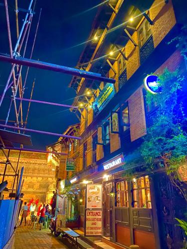 a street at night with people sitting outside a building at Shiva Guest House in Bhaktapur
