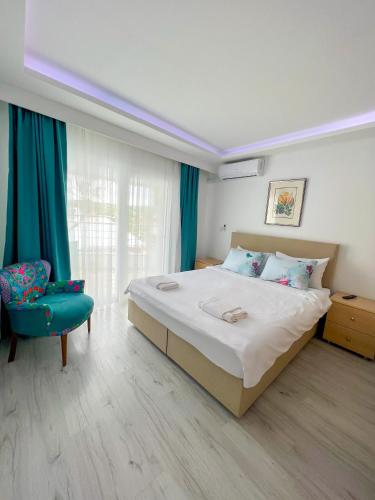 a bedroom with a large bed and a blue chair at Mercan Otel in Canakkale