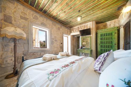 a bedroom with a bed and a stone wall at Aysel Inn House in Goreme