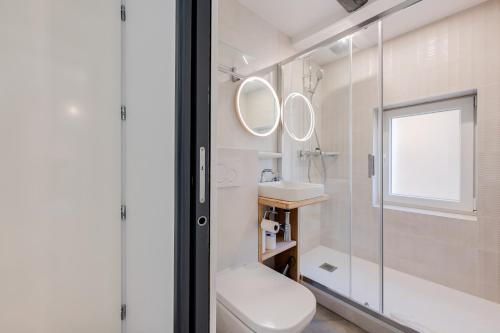 La salle de bains est pourvue de toilettes, d'un lavabo et d'un miroir. dans l'établissement L'Escale bleue, à Annecy