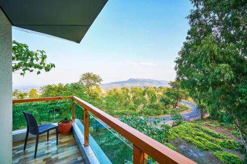 a balcony with a chair and a view of a road at hotel saptarang residency panhala in Panhāla