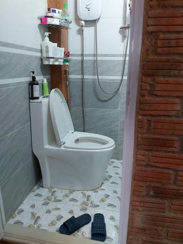 a bathroom with a toilet and some shoes on the floor at Handmade Store Măng Đen in Kon Von Kla