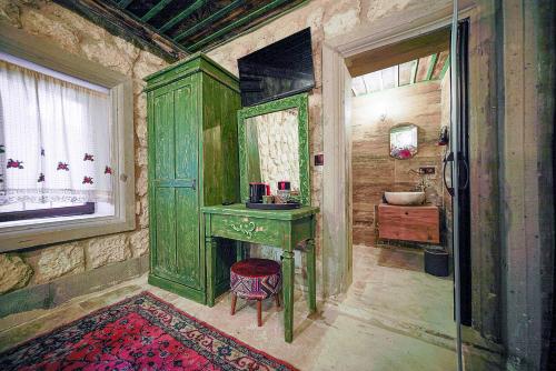 a bathroom with a green vanity and a sink at Aysel Inn House in Goreme