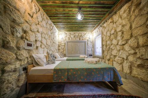 a bedroom with a bed in a stone wall at Aysel Inn House in Goreme