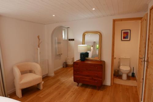 1 dormitorio con tocador, espejo y silla en Villa Jacqueline, en Dragey