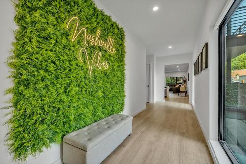 una parete di edera verde in un corridoio con una panca di Nashville Vibes @Hyve 201 a Nashville