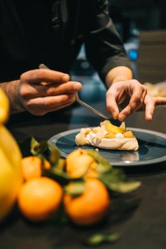 a person is eating food on a plate at Hilton Garden Inn Bordeaux Centre in Bordeaux