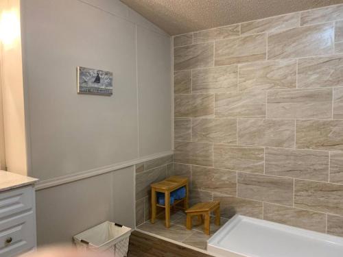 baño con bañera y pared de azulejos en Cottage Too, en Iuka