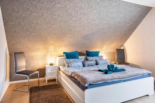 a bedroom with a king sized bed with blue pillows at Ferienwohnung Heimathafen in Cuxhaven