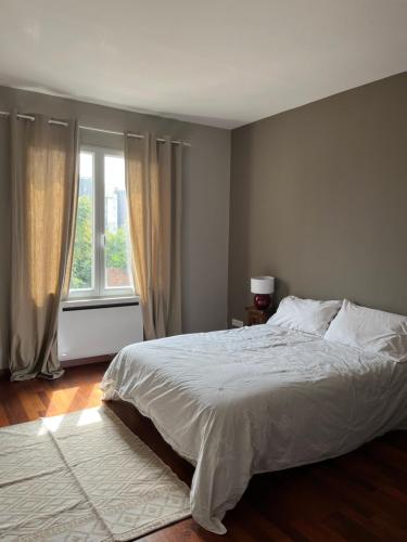 - une chambre avec un lit blanc et une fenêtre dans l'établissement Superbe appart, 15 min de paris, au calme, à Rosny-sous-Bois