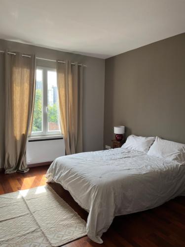 une chambre avec un lit blanc et une fenêtre dans l'établissement Superbe appart, 15 min de paris, au calme, à Rosny-sous-Bois