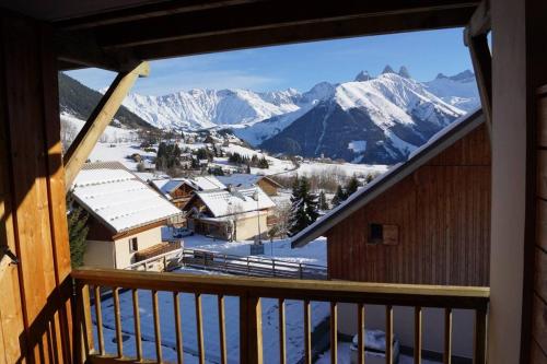a view from a balcony of a ski resort with snow covered mountains at APPARTEMENT PIEDS DE PISTE - 4-6 PERSONNES in La Chal