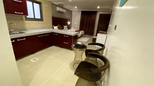 een keuken met een wastafel en 2 stoelen in een kamer bij البستان للأجنحة الفندقية in Al Hofuf