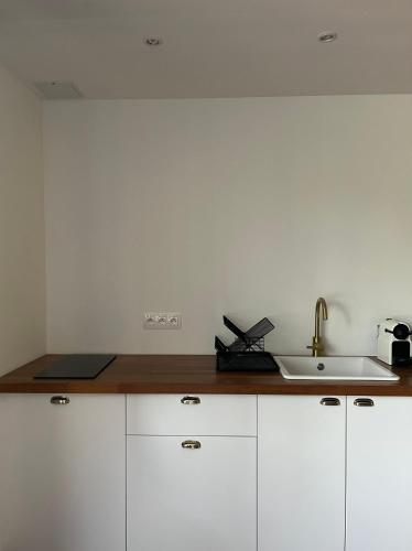 une cuisine avec des armoires blanches et un évier dans l'établissement Superbe appart, 15 min de paris, au calme, à Rosny-sous-Bois