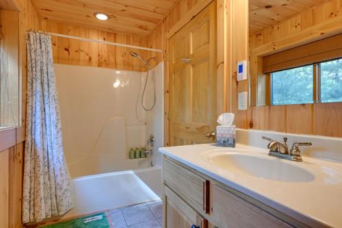 y baño con lavabo, ducha y bañera. en Cozy Arkdale Wood Cabin Near Petenwell Lake!, en New Rome