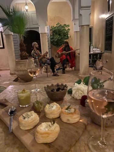 a table with some food and wine glasses on it at Riad des Fragrances dar el Bacha in Marrakech
