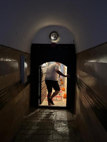a man walking through a tunnel in a building at Riad des Fragrances dar el Bacha in Marrakech