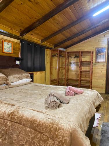 a bedroom with a large bed in a cabin at Morada das Estrelas in Cambara do Sul