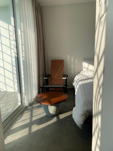 PHAM. Hotel & Views في هاي فونج: غرفة نوم بها كرسي وسرير ونافذة