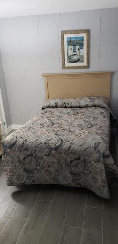 a bedroom with a bed with a comforter on it at Palmsbythebeach in Myrtle Beach