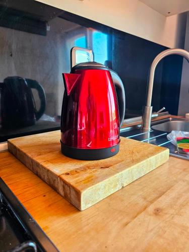 a red tea kettle sitting on a wooden cutting board at Panoramic Sunset Terrace Attic in Rome