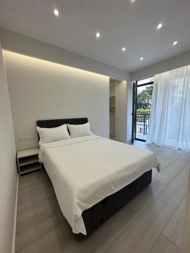sypialnia z dużym łóżkiem i dużym oknem w obiekcie GSS - 5 Apartment w mieście Tbilisi City