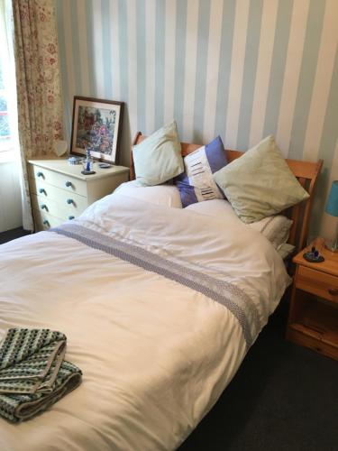 una camera con un grande letto bianco e un comò di Westbrook-Homestay a Swansea