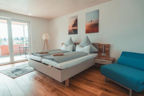 a bedroom with a bed and a blue couch at Ferienwohnung Steinablick mit großem Balkon & Garage in Ühlingen-Birkendorf