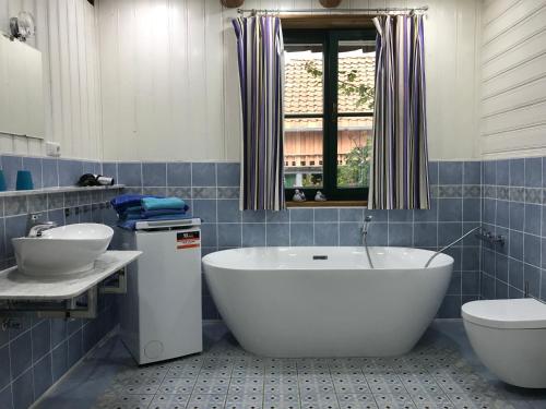 a bathroom with a tub and a toilet and a sink at Schöne gemütliche Ferienwohnung mit Kamin I im Harz in Darlingerode