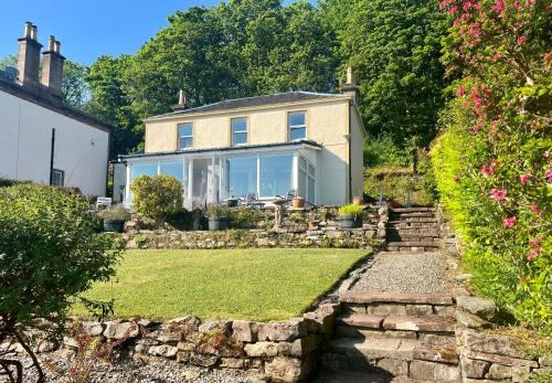 a house with a stone pathway in front of a yard at Ardmun House in Dunoon