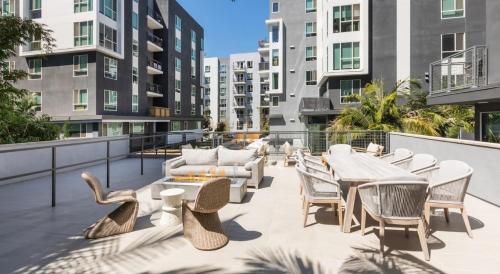 an outdoor patio with tables and chairs and buildings at DTLA Luxury Condo with Pool, Gym, Work Pods & Conference Room in Los Angeles