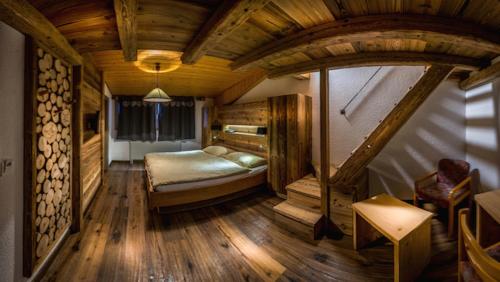 فندق لي جراند شاليه في ليسين: غرفة نوم بسرير في غرفة ذات أرضيات خشبية