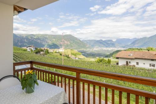 a balcony with a table and a view of a valley at Egarter in Appiano sulla Strada del Vino