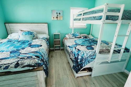 a bedroom with two beds and a bunk bed at Acapulco - Upstairs Beachview Beauty 50 steps to a private beach! BYOT in Galveston