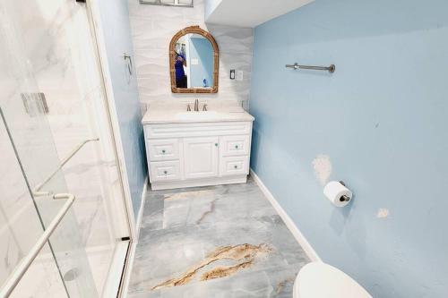 a bathroom with a sink and a toilet and a mirror at Acapulco - Upstairs Beachview Beauty 50 steps to a private beach! BYOT in Galveston
