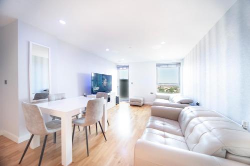 a living room with a white couch and a table at Modern 12th Floor | Balcony Striking London View in London