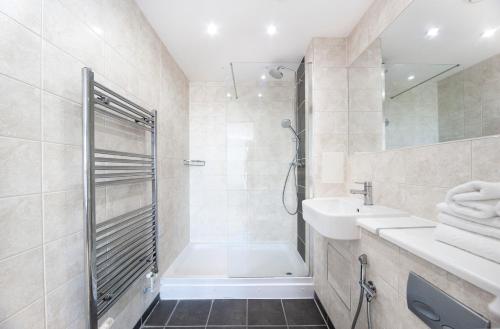 a bathroom with a tub and a sink and a shower at Modern 12th Floor | Balcony Striking London View in London