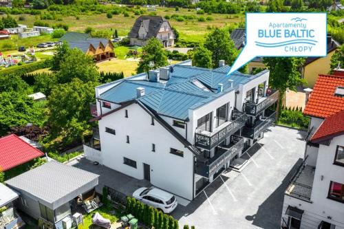 an aerial view of a white house with a blue bank sign at Apartamenty Blue Baltic Chłopy nad morzem in Chłopy