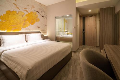a bedroom with a large bed and a bathroom at Yulia Hotel Managed by HIG in Gorontalo
