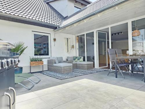 un patio con sofá, mesa y sillas en Ara - Loft, Big Terrace, BBQ, Tischkicker, PS4, Stream en Marburg an der Lahn