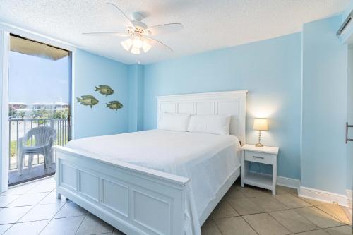 um quarto com uma cama branca e uma varanda em The Whaler 1A em Gulf Shores