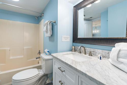 uma casa de banho com um WC, um lavatório e um espelho. em The Whaler 1A em Gulf Shores