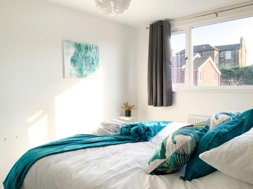 - une chambre avec un lit doté de draps bleus et une fenêtre dans l'établissement De Montfort House, à Londres