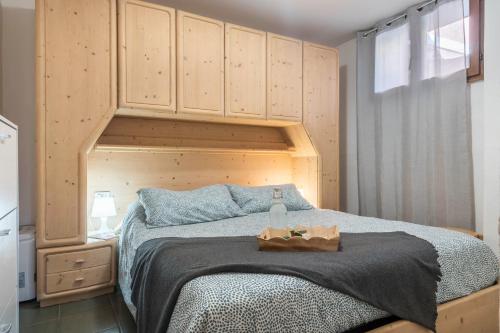 Schlafzimmer mit einem großen Bett mit einem Kopfteil aus Holz in der Unterkunft Ciasa de Lucky in Moena