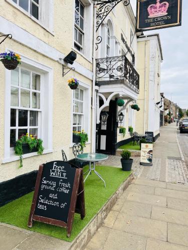 a cafe with a sign in front of a building at Crown Hotel Brackley in Brackley