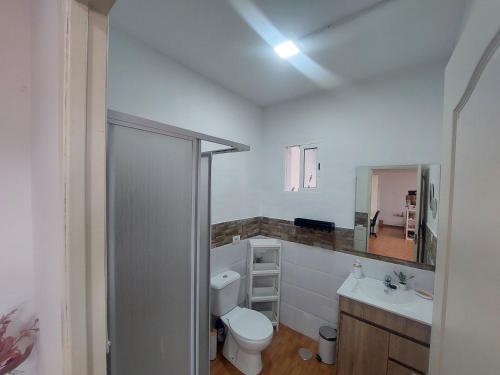 a bathroom with a toilet and a sink and a mirror at Casa Lito B in Haría